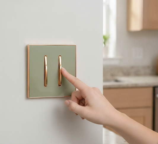 Hand pressing a modern light switch on a wall in a kitchen.