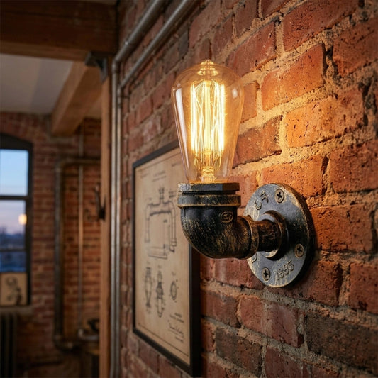 Industrial-style wall sconce with a glowing filament light bulb mounted on a brick wall.