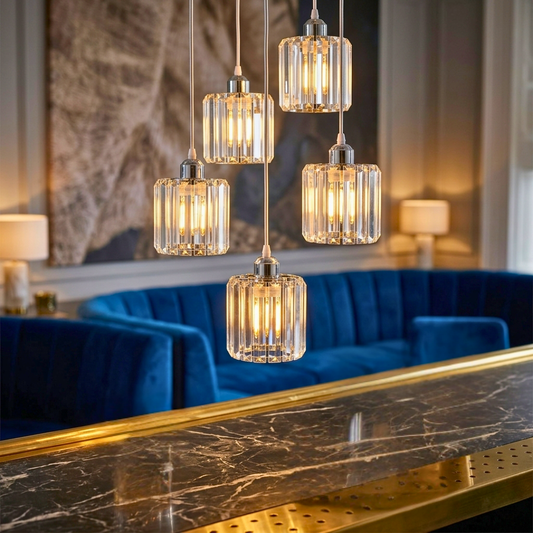 Modern chandelier with glass shades in a stylish room with blue sofa and marble table.