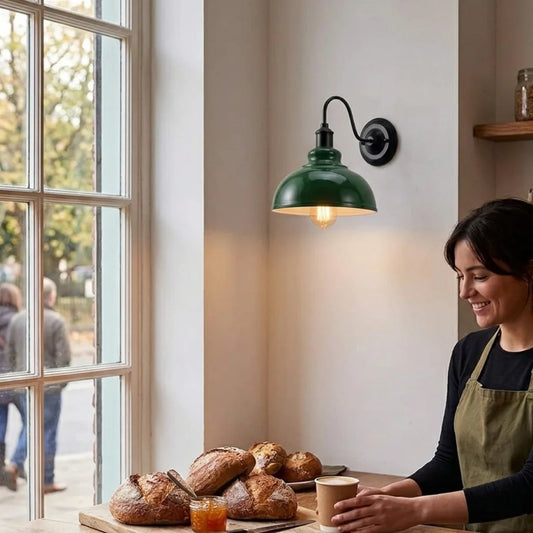Woman in a bakery with bread and a green wall lamp.