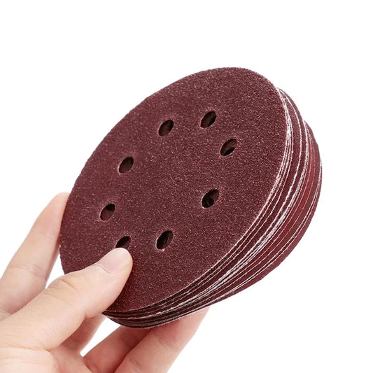 hand holding a stack of 125mm 8-hole sanding discs
