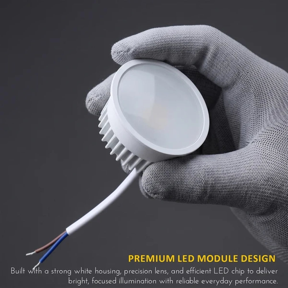 gloved hand holding a 9W GU10 LED module with bare wires