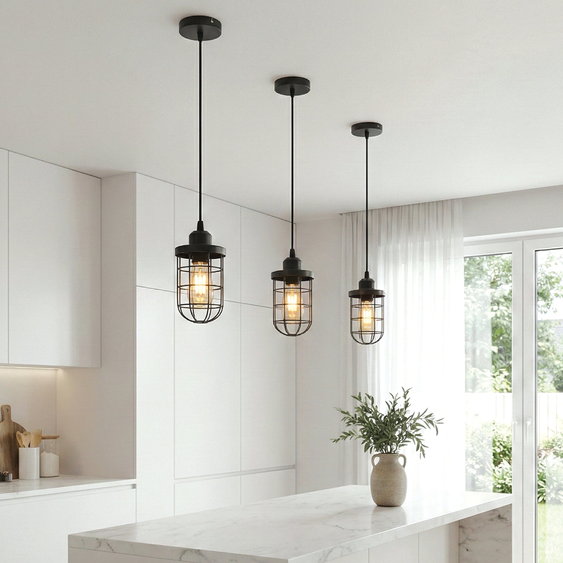 Three pendant lights hanging in a modern kitchen with white cabinets and a window.