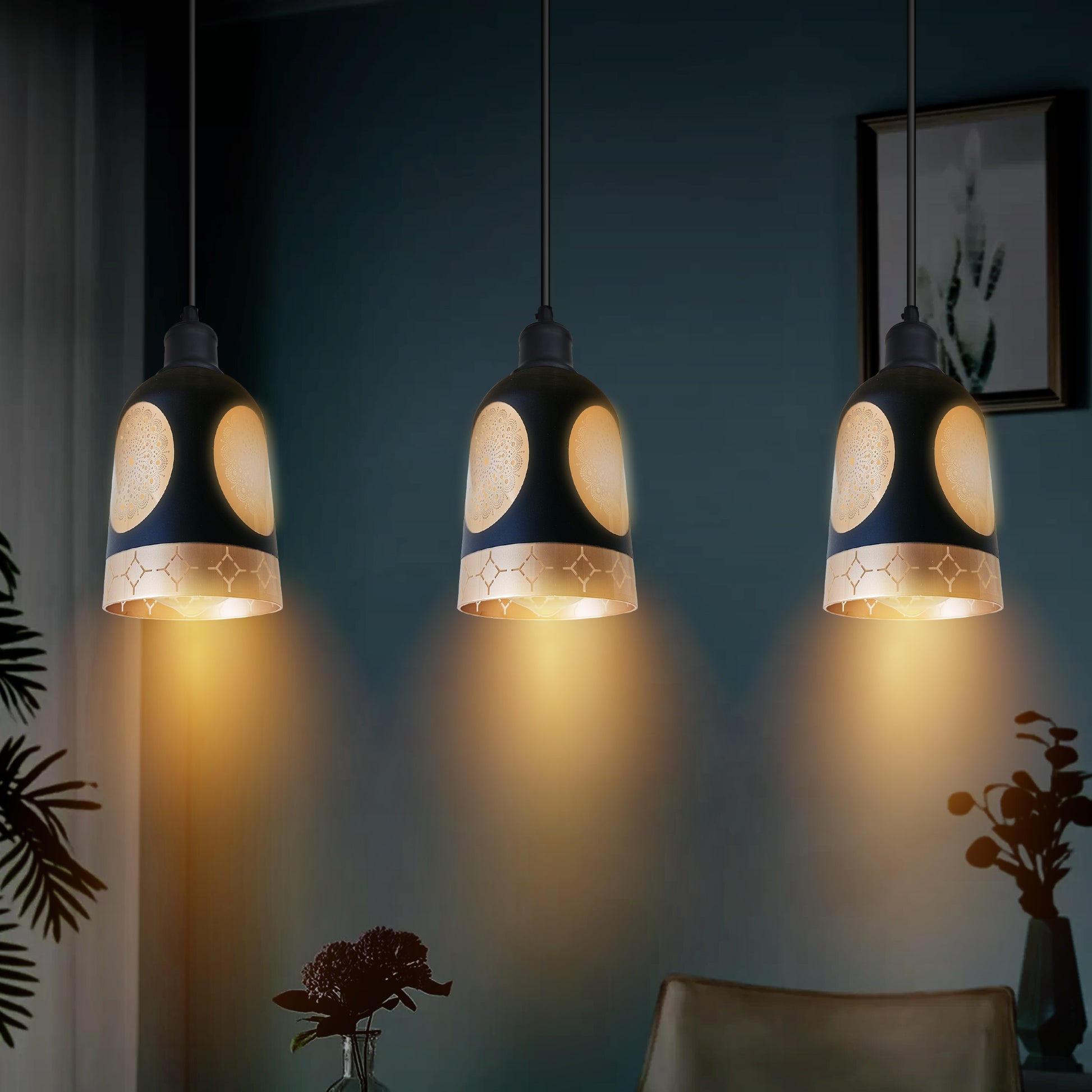Three pendant lights hanging in a room with a dark wall and decorative elements.