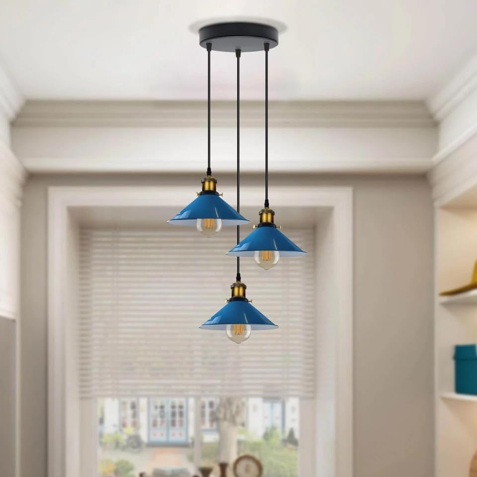 Three blue pendant lights hanging from the ceiling in a room with a window.