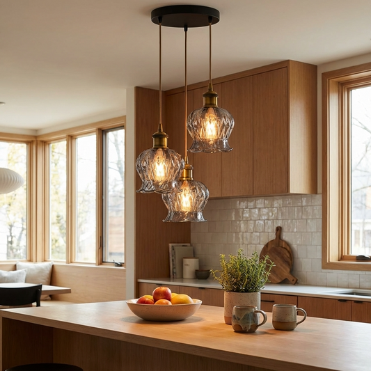 Modern kitchen with wooden island, pendant lights, and a bowl of fruit.
