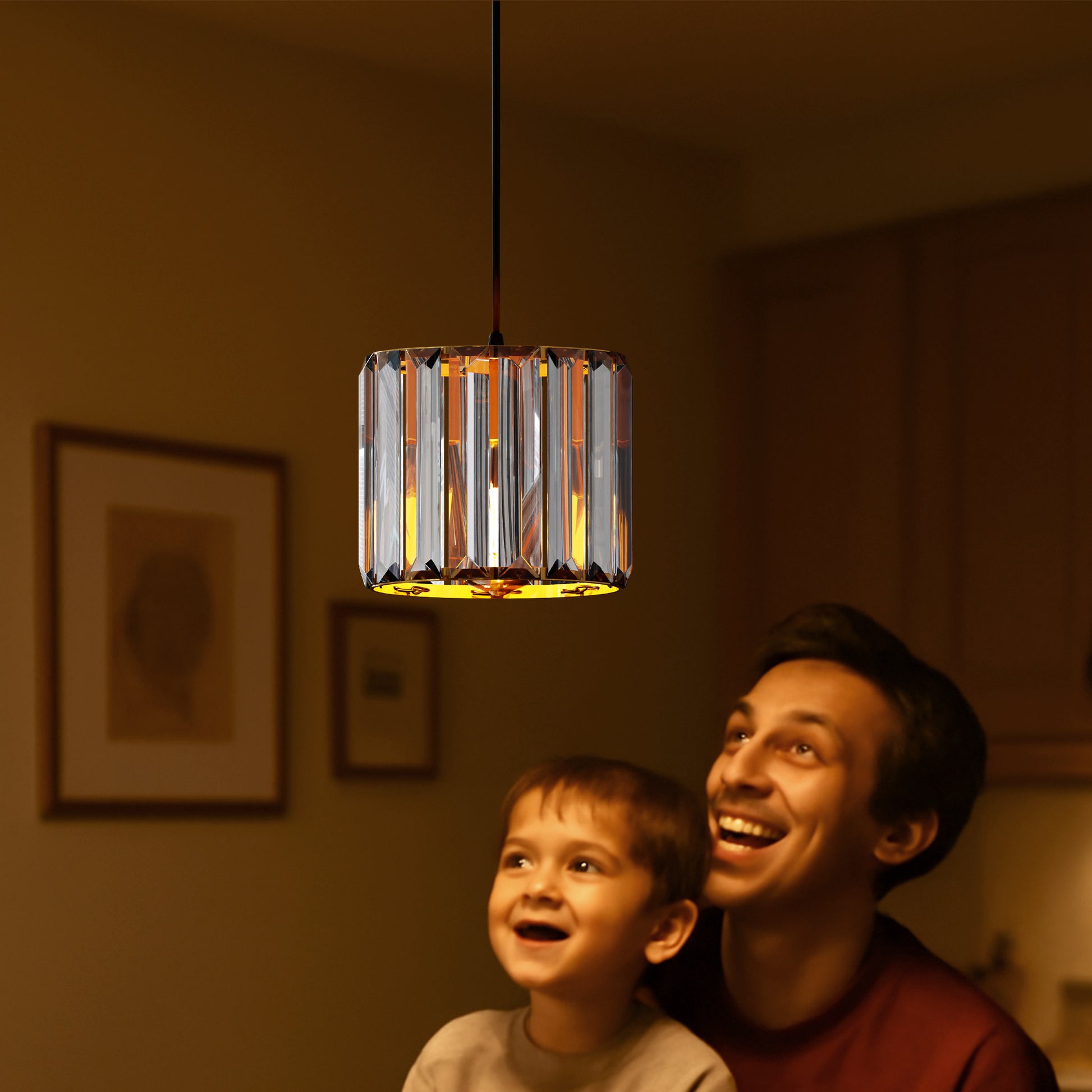 Man and child looking up at a modern pendant light fixture in a warm-lit room.