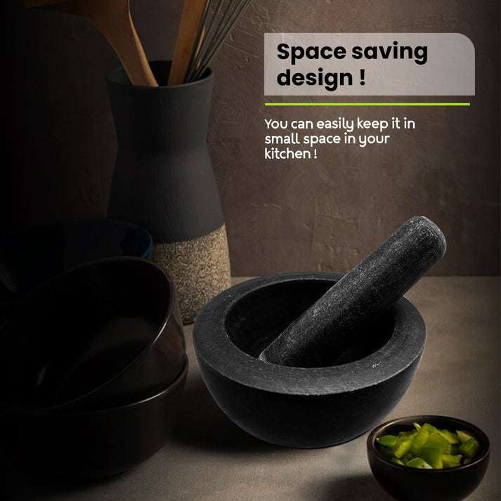 A large black granite pestle and mortar set, a classic kitchen gadget.
