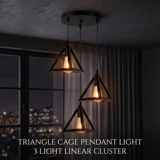 Three triangle cage pendant lights hanging in a linear cluster from a ceiling, with warm glowing bulbs inside. The scene is set in a dimly lit room with curtains and a window showing a city night view.