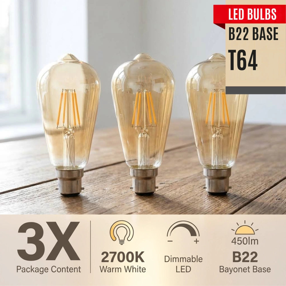 Three clear glass LED light bulbs with visible warm white filaments and bayonet bases, shown on a wooden surface with product information text overlays including 'LED Bulbs', 'B22 BASE', 'T64', '3X Package Content', '2700K Warm White', 'Dimmable LED', and '450lm B22 Bayonet Base'.