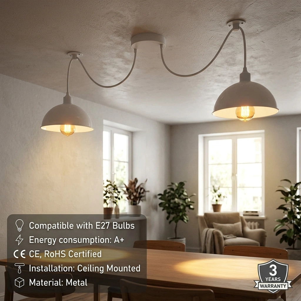 A two-light ceiling pendant fixture with two white dome-shaped shades on curved metal arms, shown installed in a bright dining room. Text overlays specify compatibility with E27 bulbs, energy consumption, installation details, and a 3-year warranty badge.