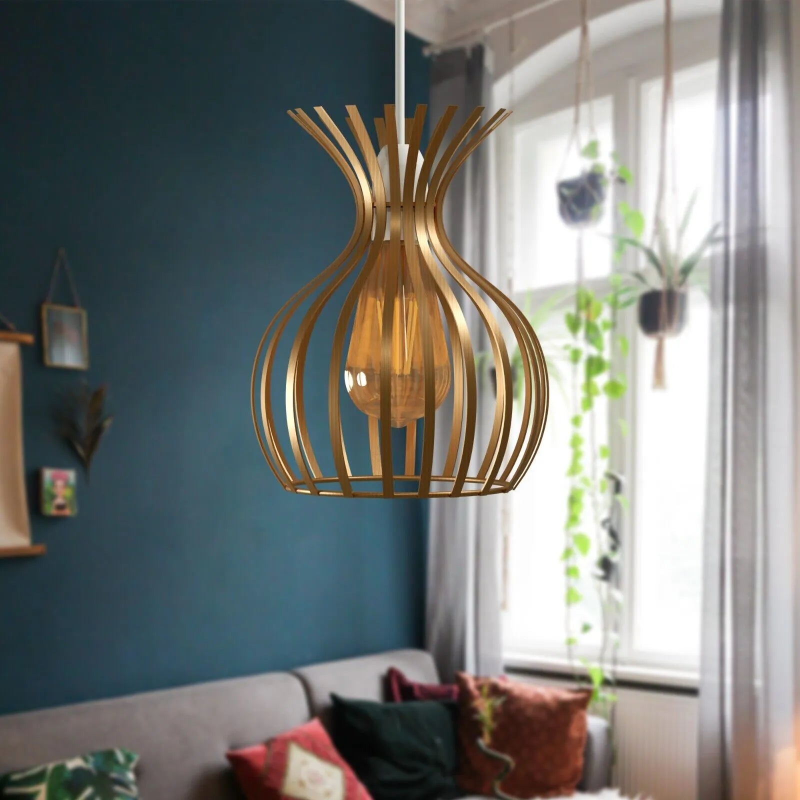 A copper metal wire cage lamp shade in a vase shape, hanging from the ceiling, with a light bulb inside.