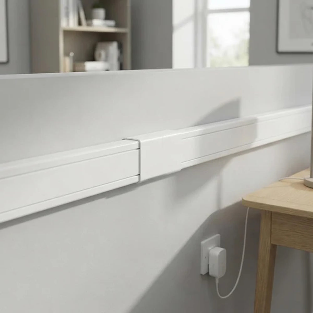 white trunking and straight connector along a wall near a desk